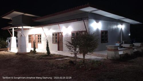 a small white house with lights on it at night at Suanlamyai Resort in Loei