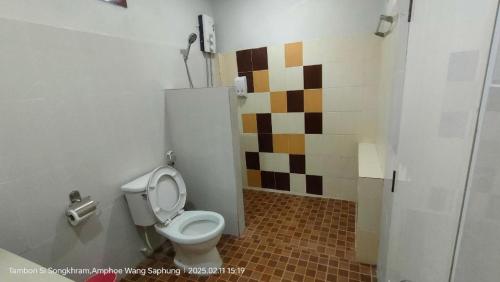 a bathroom with a toilet and a tiled wall at Suanlamyai Resort in Loei