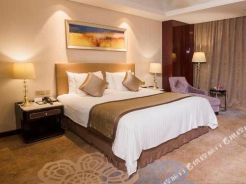 a bedroom with a large bed in a hotel room at Dongwu New Century Grand Hotel Huzhou in Huzhou