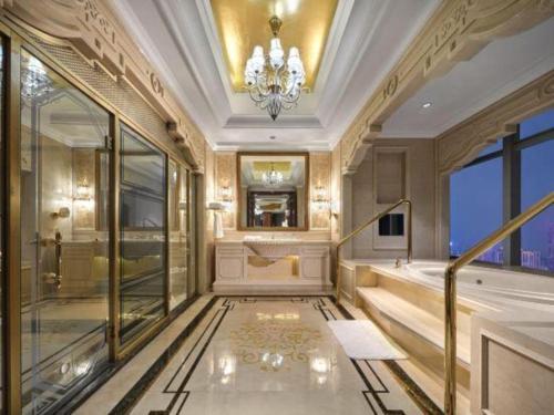 a bathroom with a chandelier and a walk in shower at Dongwu New Century Grand Hotel Huzhou in Huzhou