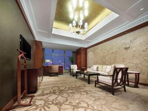 a living room with a couch and a tv at Dongwu New Century Grand Hotel Huzhou in Huzhou