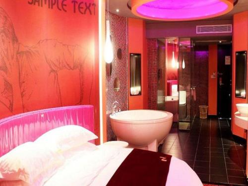 a bathroom with a bed and a tub and a toilet at Grand Nest Hotel (Tang Jia Wan Beach) in Zhuhai