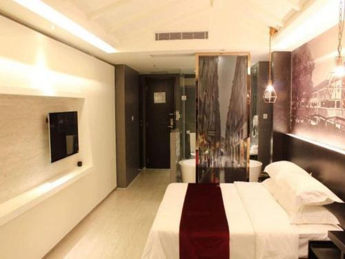 a hotel room with a bed and a bathroom at Grand Nest Hotel (Tang Jia Wan Beach) in Zhuhai