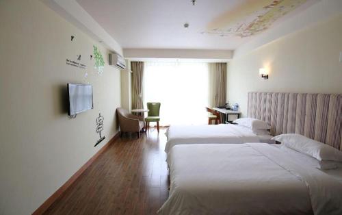 a hotel room with two beds and a television at Grand Nest Hotel (Tang Jia Wan Beach) in Zhuhai