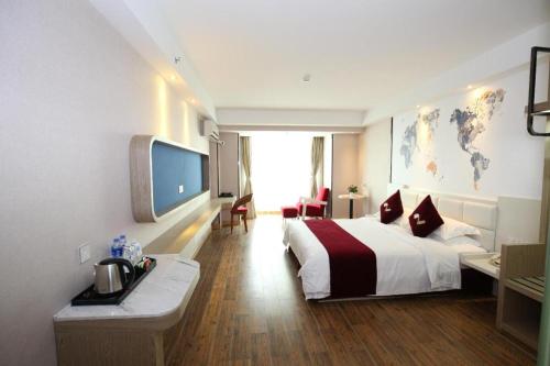 a hotel room with a large bed and a desk at Grand Nest Hotel (Tang Jia Wan Beach) in Zhuhai