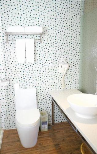 a bathroom with a white toilet and a sink at Grand Nest Hotel (Tang Jia Wan Beach) in Zhuhai