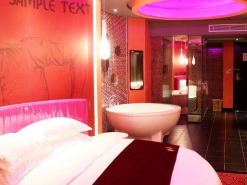 a bathroom with a bed and a tub and a sink at Grand Nest Hotel (Tang Jia Wan Beach) in Zhuhai
