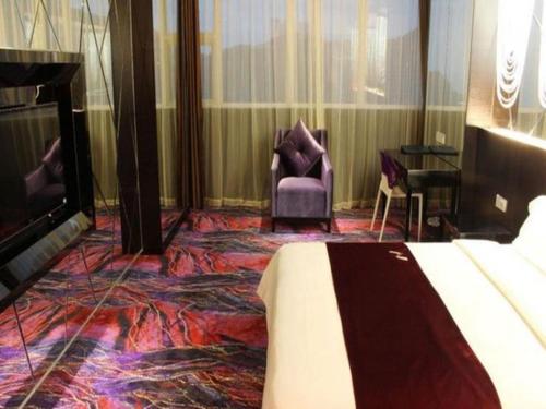 a hotel room with a bed and chairs and a piano at Grand Nest Hotel (Tang Jia Wan Beach) in Zhuhai