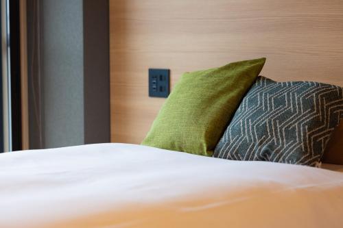 Una cama o camas en una habitación de 奥州平泉温泉旅館 itsumu