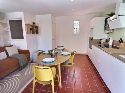 une cuisine et un salon avec une table et des chaises dans l'établissement Le chateau de ma mère- climatisé -duplex- 4 personnes, à Aubagne