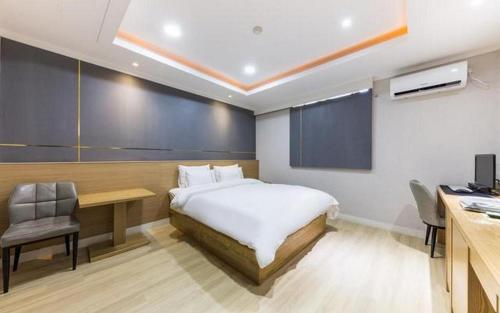 a bedroom with a bed and a desk and a computer at Hotel Primo Daejeon in Daejeon