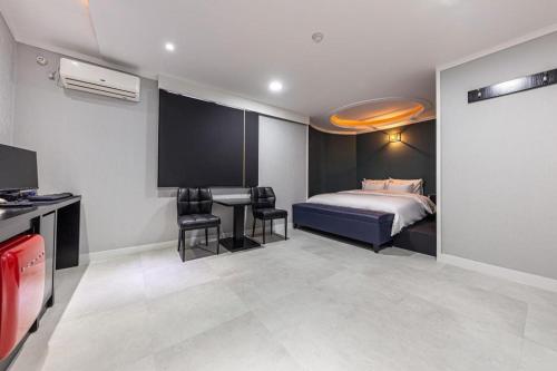 a bedroom with a bed and a table and chairs at Hotel Primo Daejeon in Daejeon