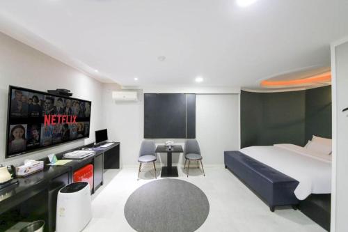 a bedroom with a bed and a table and chairs at Hotel Primo Daejeon in Daejeon