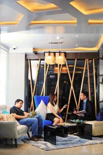 a group of people sitting on a couch in a living room at Hotel Estrella in Tacloban