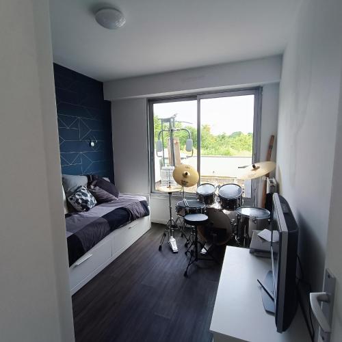 une chambre avec un lit et une fenêtre avec des tambours dans l'établissement La canopée : séjour alliant culture, nature, sport, à Nantes