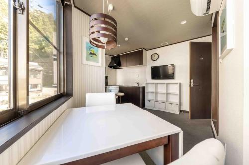a small kitchen with a white table and a window at Address Nagasaka in Nozawa Onsen