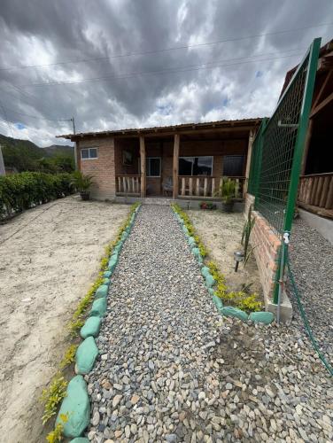 a house with a fence and some rocks in front of it at Rustic Villa in a Natural Setting in Loja