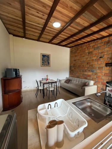 a kitchen with a sink and a living room with a table at Rustic Villa in a Natural Setting in Loja