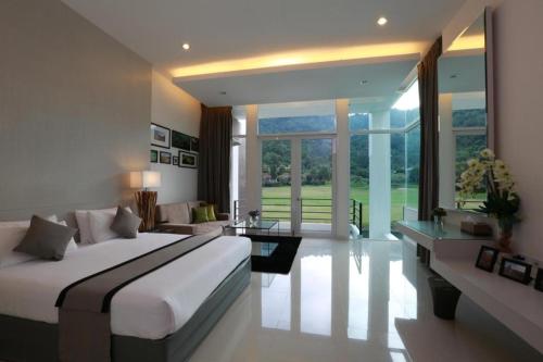 a bedroom with a large bed and a living room at Royal Hills Golf Resort and Spa in Ban Som Phung Haeng (1)
