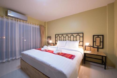 - une chambre dotée d'un grand lit avec deux ours en peluche dans l'établissement Bees Smile Hotel, à Chiang Rai