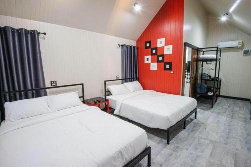 a room with two beds and a red wall at KATOON RESORT KHAO KHO in Campson
