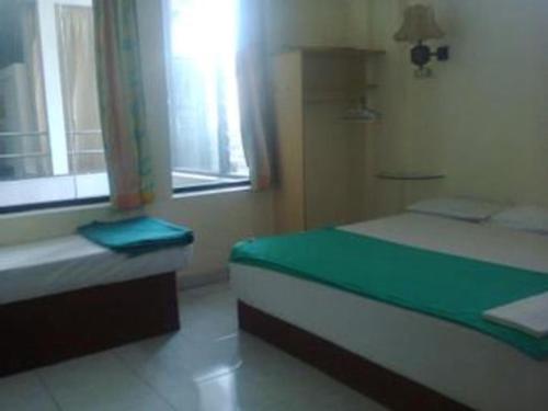 a bedroom with a bed and a window at Mitra Hotel Yogyakarta in Yogyakarta