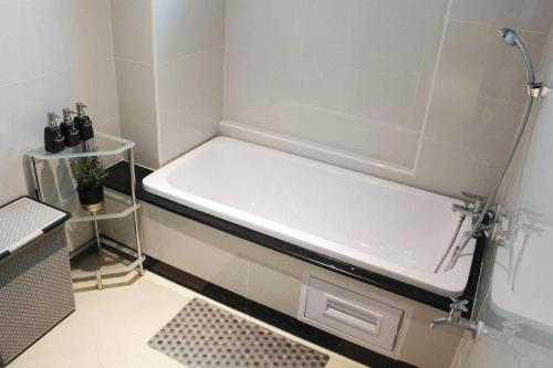 una vasca da bagno bianca in un bagno con lavandino di The Finn Hotel a Nakhon Ratchasima
