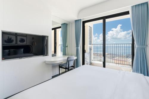a hotel room with a bed and a balcony at Hillside Luxury Phu Quoc Apartment in Phu Quoc