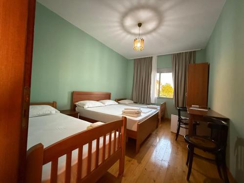 una camera con 2 letti, una scrivania e una finestra di Meti guest house a Krujë (Kruja)