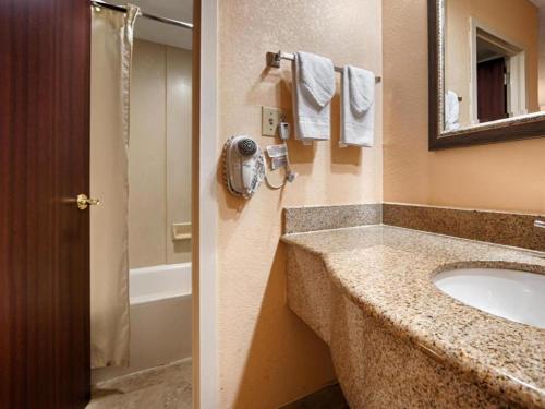 een badkamer met een wastafel en een spiegel bij Best Western Spanish Quarters Inn in St. Augustine