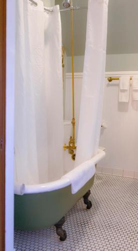 a bath tub with a shower curtain in a bathroom at Cabernet House, an Old World Inn in Napa