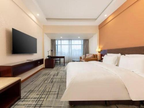 a hotel room with a large bed and a flat screen tv at Movie Star Hotel in Guangzhou