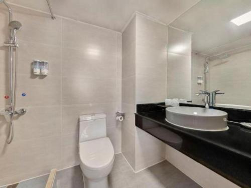 a bathroom with a white toilet and a sink at Movie Star Hotel in Guangzhou