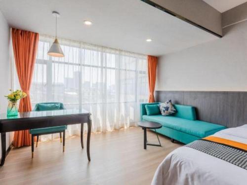 a bedroom with a bed and a desk and a couch at Movie Star Hotel in Guangzhou