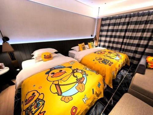 two beds with winnie the pooh on them in a room at Movie Star Hotel in Guangzhou