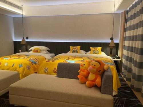 a bedroom with two beds with stuffed animals on it at Movie Star Hotel in Guangzhou