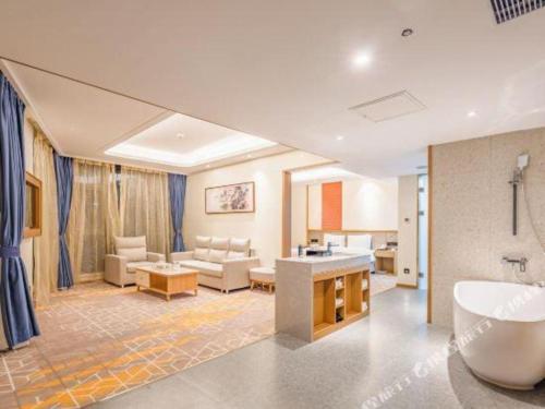 une salle de bain avec baignoire et un salon dans l'établissement Gtel Rock City Qingdao Hotel, à Laoshan