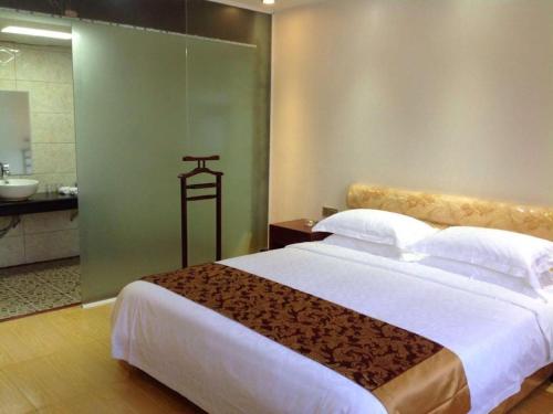 a bedroom with a large bed and a bathroom at Jian Guo Grand Hotel in Vientiane