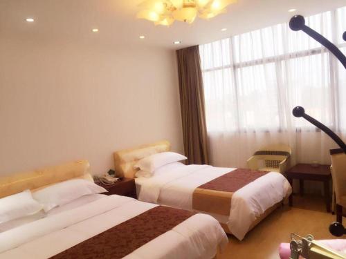 a hotel room with two beds and a window at Jian Guo Grand Hotel in Vientiane