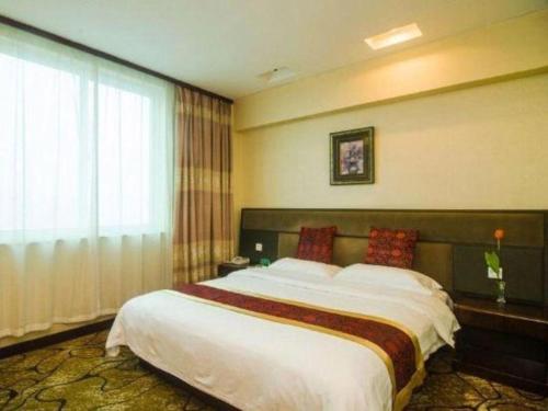 a bedroom with a large bed and a large window at GreenTree Alliance Zhejiang Zhoushan Putuoshan Zhujiajian Scenic Spot Hotel in Zhoushan