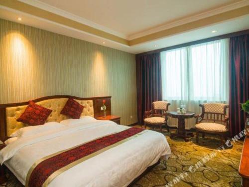 a hotel room with a large bed and a large window at GreenTree Alliance Zhejiang Zhoushan Putuoshan Zhujiajian Scenic Spot Hotel in Zhoushan