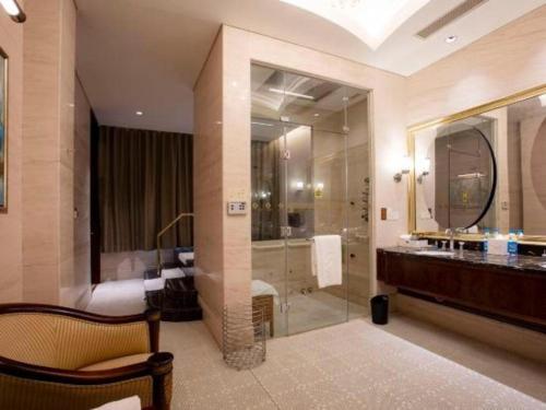 a bathroom with a shower and a sink and a mirror at Suzhou Jinji Lake Grand Hotel in Suzhou