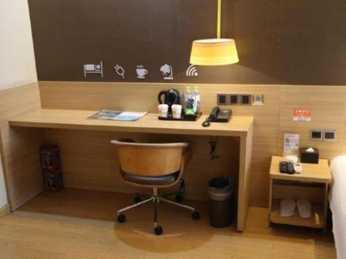 a desk in a hotel room with a chair at IU Hotel Chengdu High-Tech Zone Longhu Times Street in Chengdu
