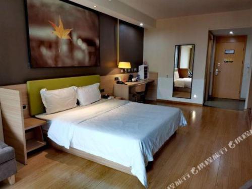 a bedroom with a large bed and a mirror at IU Hotel Chengdu High-Tech Zone Longhu Times Street in Chengdu