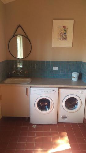 a kitchen with a washer and a washing machine at The Cottage at Riverside Farm in Lyndoch