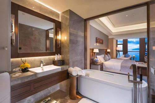 a bathroom with a bed and a tub and a sink at Dali Hotel in Dali