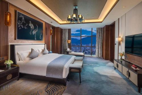 a bedroom with a large bed and a large window at Dali Hotel in Dali