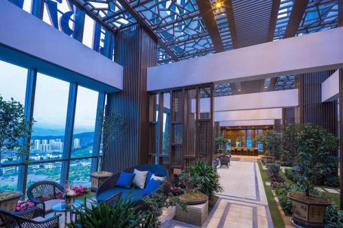 a lobby with a blue couch in a building with windows at Dali Hotel in Dali