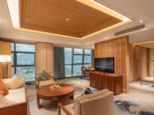 a living room with a couch and a television at Dali Hotel in Dali