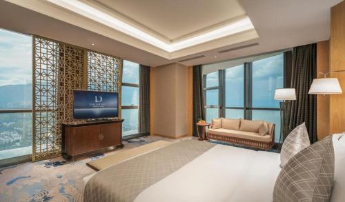 a bedroom with a bed and a tv and windows at Dali Hotel in Dali